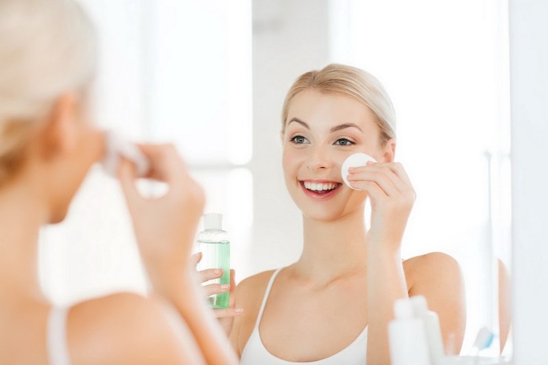 Dùng bông tẩy trang hoặc bông y tế thấm nước muối sinh lý để lau nhẹ nhàng vùng da mặt.